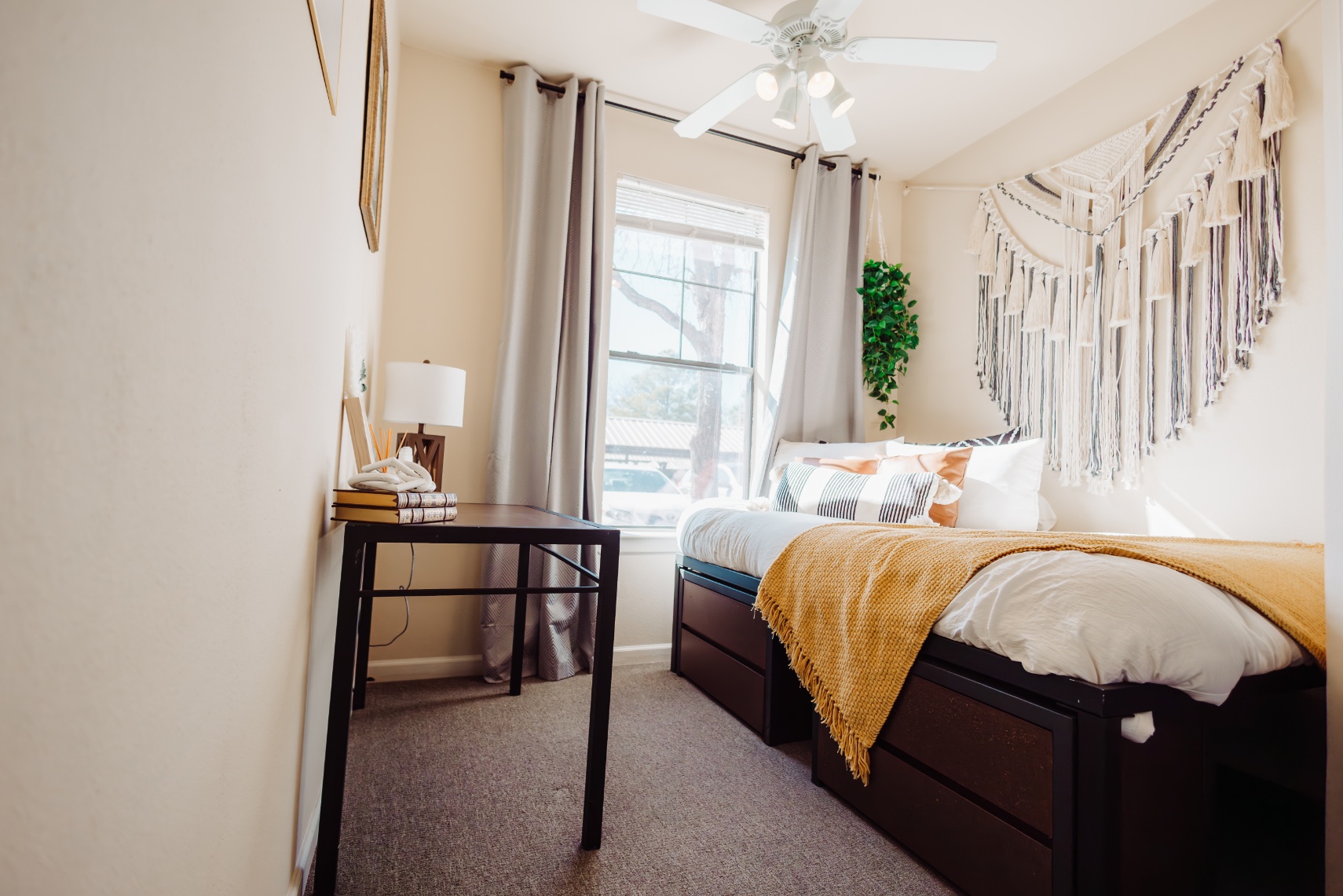 Carpeted model bedroom with a ceiling fan at Maverick Place