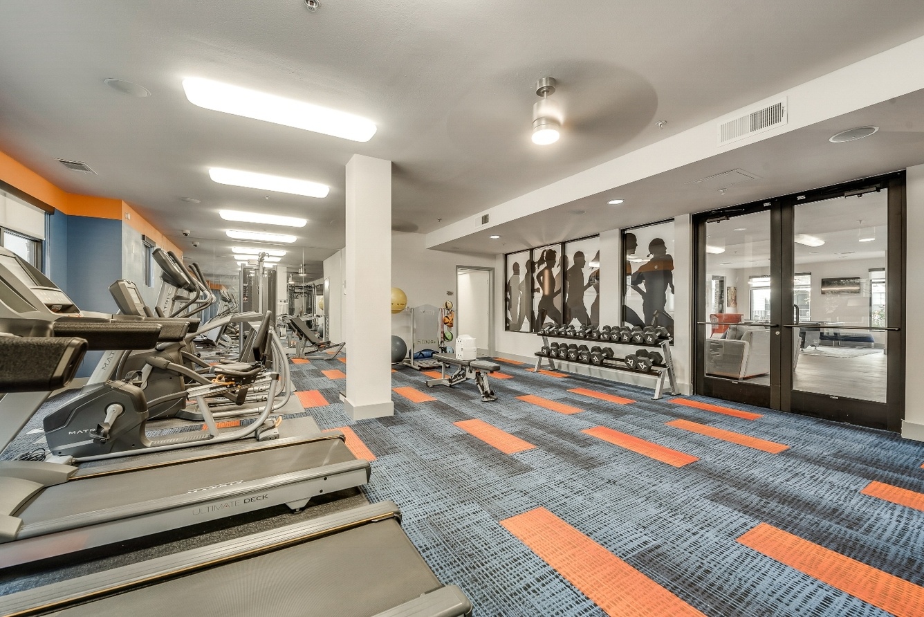 Fitness center with cardio equipment and free weights at Maverick Place